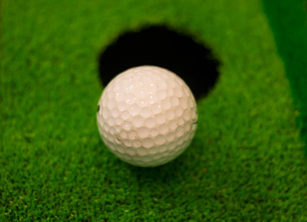 istock golf ball on lip of cup 524717253