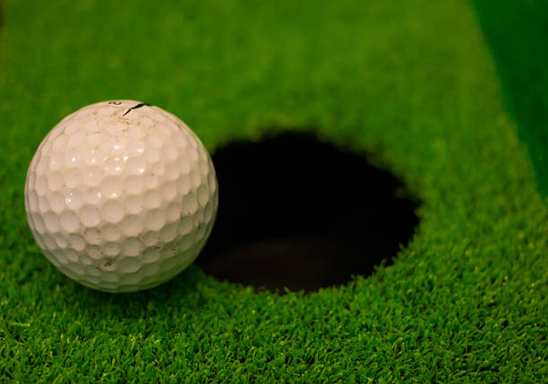 istock golf ball on lip of cup 524717295