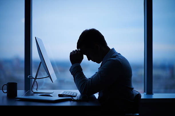 Working late Tired or stressed businessman sitting in front of computer in office emotional stress stock pictures, royalty-free photos & images