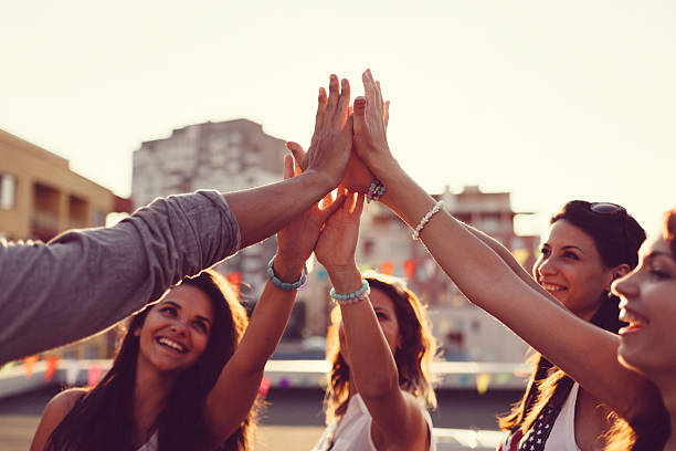 Happy friends high fiving Happy friends celebrating the success with high five teenage girls dusk city urban scene stock pictures, royalty-free photos & images