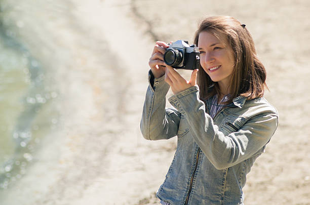 istock Young woman with retro camera at beach 524719746
