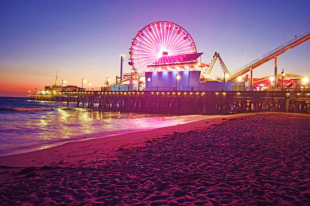 Santa Monica Pier at Night Santa Monica Pier and Ferris Wheel at night showing off all of the beautiful colored lights. Santa Monica is a city within Los Angeles, California. santa monica stock pictures, royalty-free photos & images