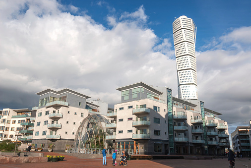 Malmo, Sweden - October 12, 2014: Västra hamnen (Western Harbour) neighbourhood in Malmö. There are many residential building overlooking the Oresund strait. Behind this building is Turning Torso skyscraper, Malmo's lendmark.