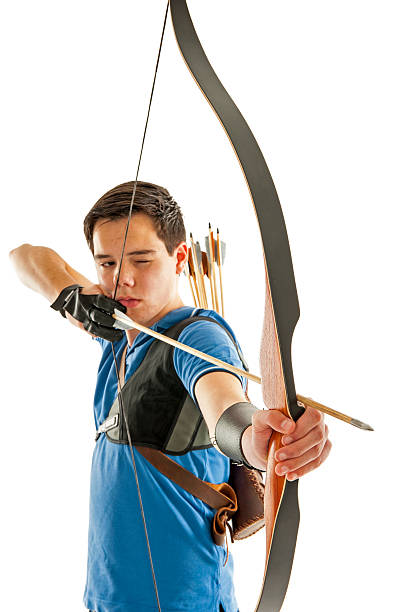 Boy aiming with bow an arrow Boy with blue shirt and jeans shootling with a longbow archery bow stock pictures, royalty-free photos & images
