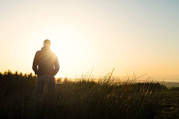 istock Man stood in countryside with late afternoon sun flare 524722276