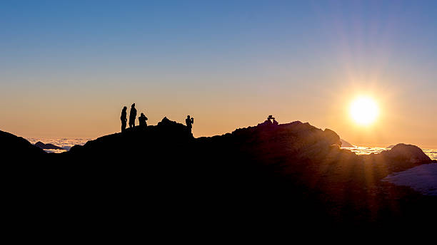 istock silhouette of people standing on a mountain ridge 524723873