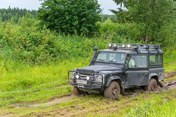 Winching of Land Rover Defender vehicle sunk in mud Kazovo, Russia - June 23, 2010: Winching of Land Rover Defender vehicle sunk in mud.  cable winch stock pictures, royalty-free photos & images