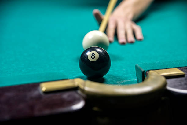 istock man playing billiards in dark club 524724326