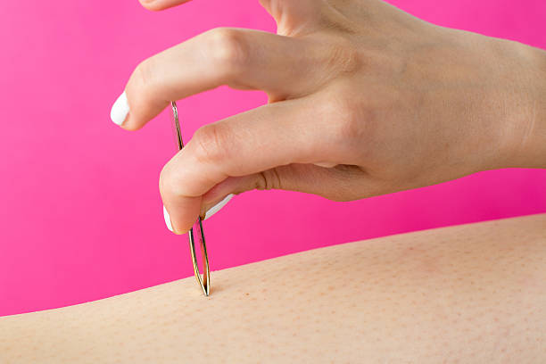 Woman pulling hair with a tweezers stock photo