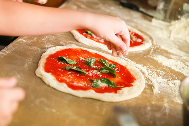 istock Preparing Pizza. Cook adds grated parmesan 524727836
