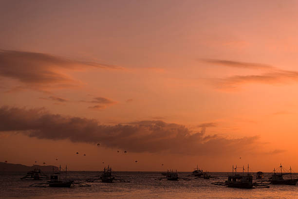 Boats and parachutes silhouettes in Boracay Philippines beach