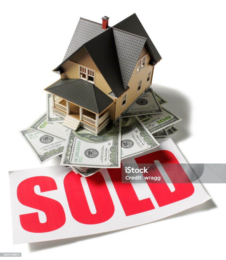 Red Sold Sign with American Dollars and Toy Model House Toy model house on the top of American dollars with a red sold sign, isolated on white. Real Estate Stock Photo