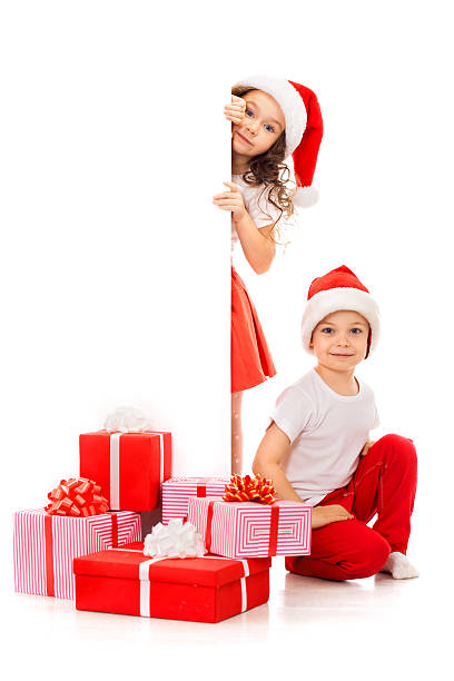 feliz pouco crianças em santa chapéu espreitar por detrás do controlo em branco - christmas child little boys peeking imagens e fotografias de stock