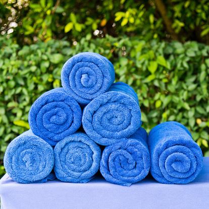 Group of blue rolled towels on table.