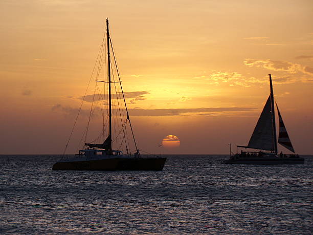 catamarano e barca a vela al tramonto ad aruba - sailing sailboat sunset aruba foto e immagini stock