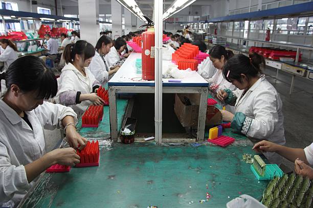 chinese trabajadores montar encendedores en fábrica. - chinese production fotografías e imágenes de stock