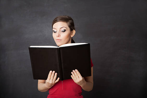 istock Woman with book. Blackboard background 524773197