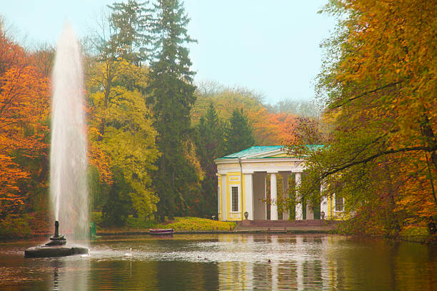 istock Autumn park  lake with a fountain scene 524773267