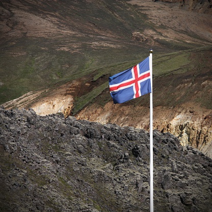 Icelandic flag. Beautiful mountains in Iceland. Famous volcanic area with rhyolite rocks - Landmannalaugar. Lava field black rocks. Square composition.