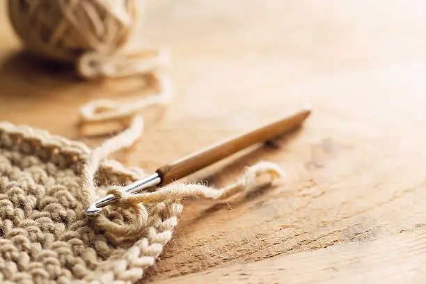 Crochet hook on wooden background