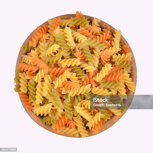 Italian Pasta Fusilli In A Wooden Bowl On A White Stock Photo - Download Image Now - Abstract, Bowl, Carbohydrate - Food Type