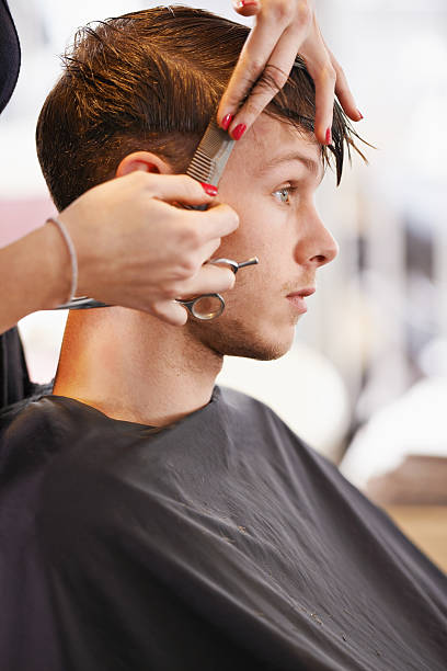 Serious style Cropped shot of a young man having his hair cut by a stylist hair length stock pictures, royalty-free photos & images