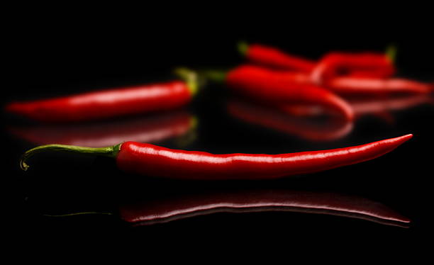 istock Studio shot of chilli peppers on black 524779231