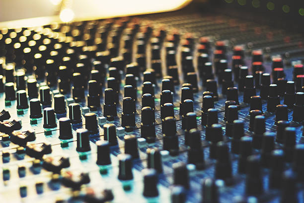 Sound recording studio - buttons and sliders on mixing console; close up, selective focus;