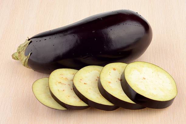 istock Studio shot single wet aubergine eggplant on wooden table 524816439