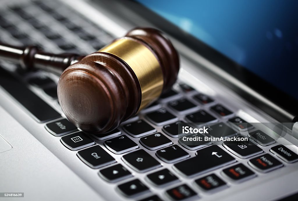 Justice gavel and laptop computer keyboard Gavel on laptop computer keyboard concept for online internet auction or legal assistance Remote Location Stock Photo