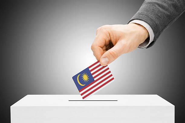 Male inserting flag into ballot box - Malaysia stock photo