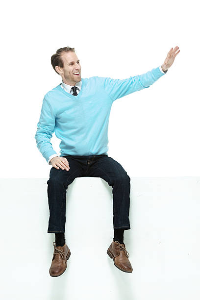 istock Cheerful man sitting on box waving hand 524821331
