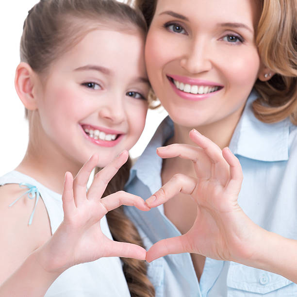 istock mother and young daughter with heart shape sign 524824193