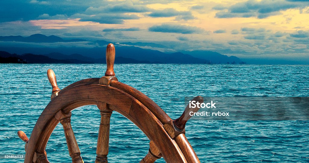Steering wheel Steering wheel at sea background.  Skipper's wheel on an old ship. Sea voyage at the seaside with captains wheel of the old vessel, closeup. Sailboat Stock Photo