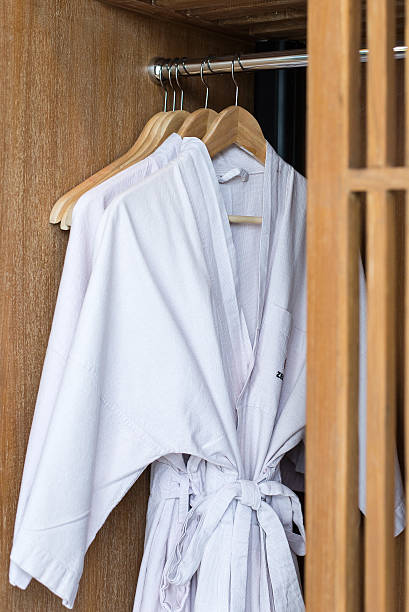 istock white bathrobe with wooden hangers in wardrobe 524856733