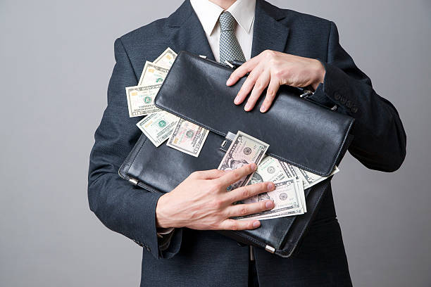 homme d'affaires avec une valise pleine de l'argent dans les mains - book holding necktie businessman photos et images de collection