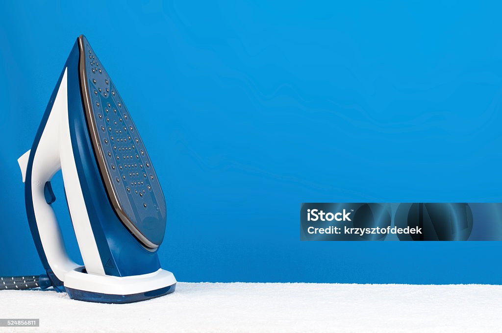 ironing blue iron on blue background Backgrounds Stock Photo