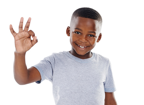 Studio shot of a cute little boy  giving you the ok sign against a white background