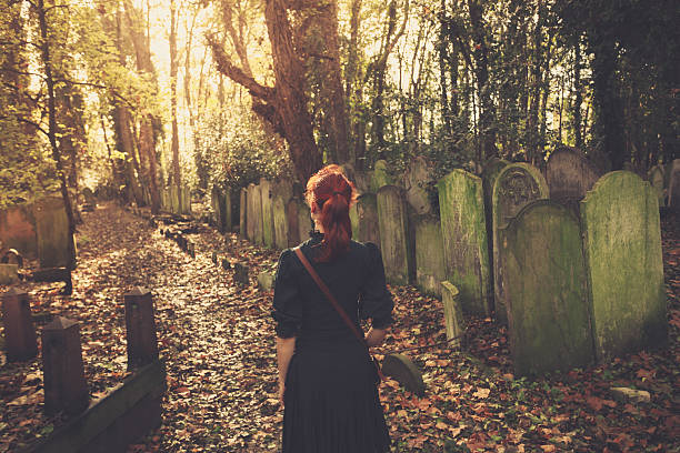 istock Woman walking amongst tombstones 524857401