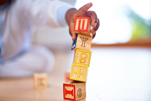 Cropped shot of a baby boy playing with wooden building blocks on the floor