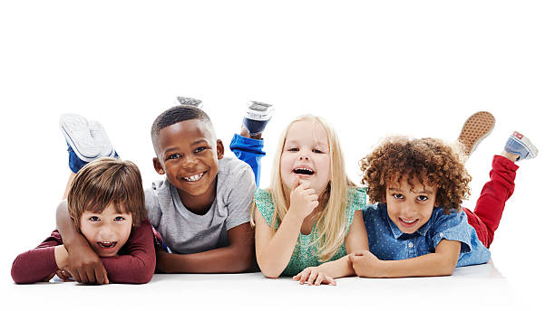 Being together makes us happy Studio shot of a group of young friends lying on the floor together against a white background smiling kids on white stock pictures, royalty-free photos & images
