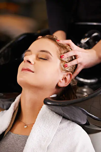 Shot of a young woman having her hair washed at a hair salon