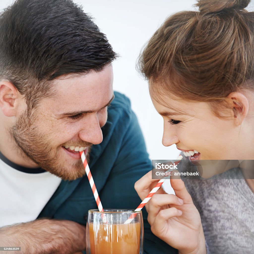 It's almost as sweet as you... Shot of an attractive young couple sharing a milkshake together Couple - Relationship Stock Photo