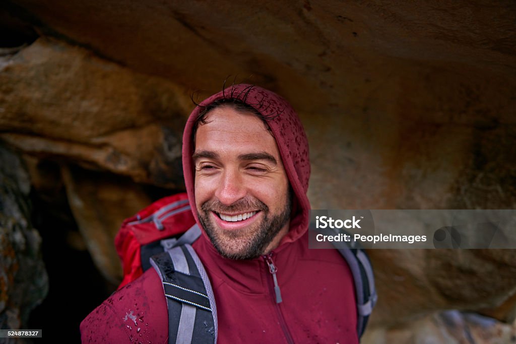 Entering a cave Shot of a young man enjoying a hike through the mountains Active Lifestyle Stock Photo