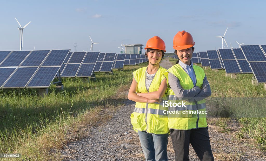 Future electrical production, asian engineers workers at a renewable energy plan, young asian engineers  working in  solar power station. Electrician Stock Photo