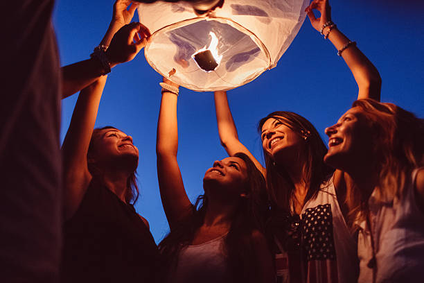 istock Friends releasing paper lantern 524882868