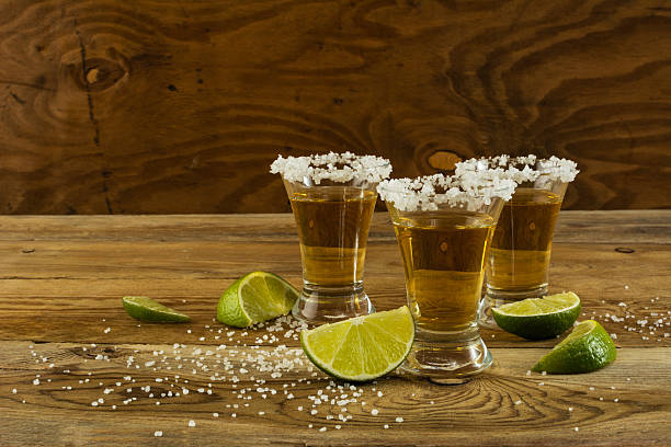 zwei gold tequila-shots, textfreiraum - tequila shot tequila salt lemon stock-fotos und bilder