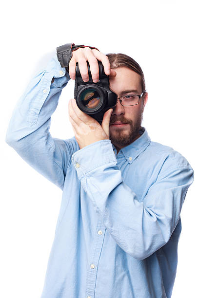 istock Young bearded man in shirt taking picture with camera isolated 524885727