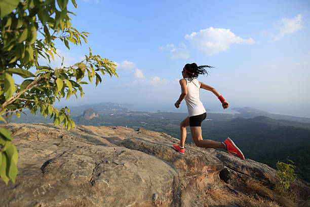 istock young asian woman runner running on mountain peak 524887458