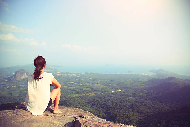 istock woman enjoy the view at mountain peak cliff 524888080